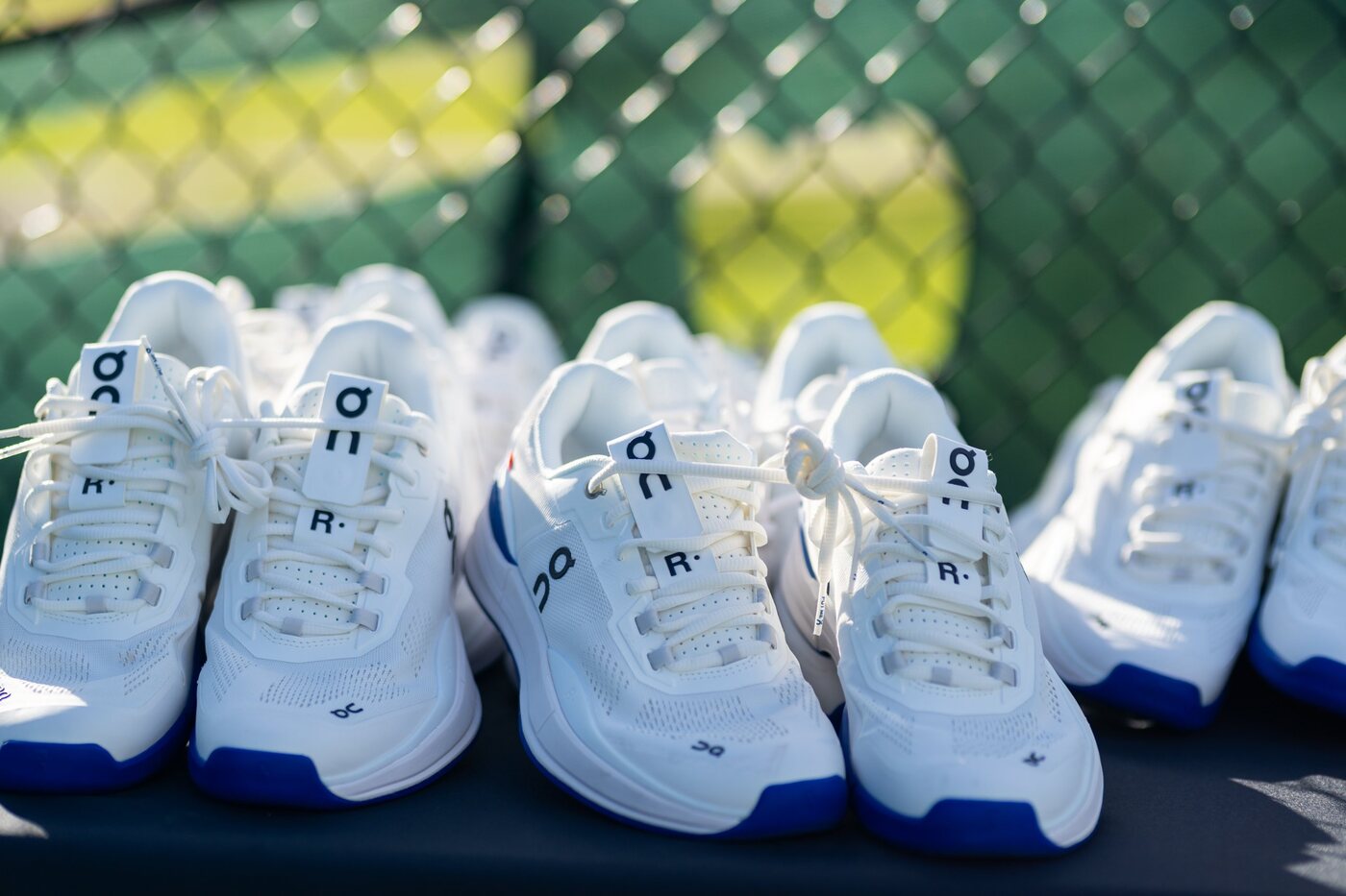 On tennis shoes lined up courtside for a partner activation
