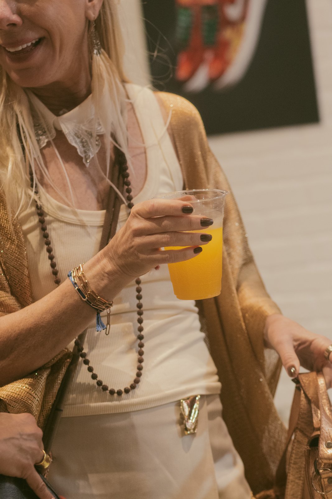 Smiling guest with a drink at Culture Court during Miami Art Week